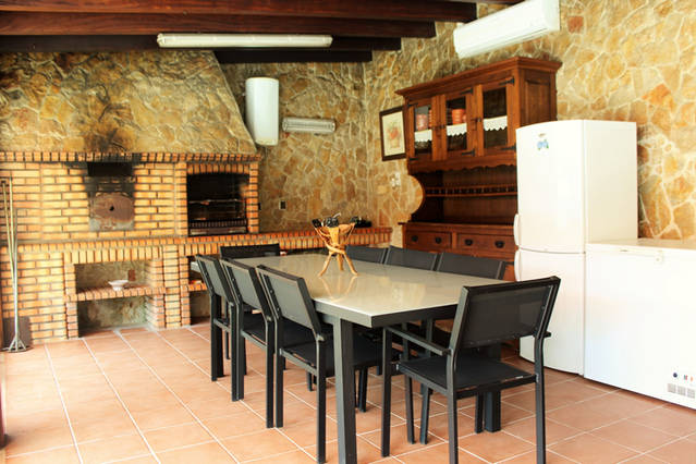 Espaço com mesa e churrasqueira